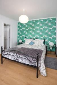 een slaapkamer met een bed met een groene muur bij Dom Pipas Houses - Batista & Marcelino Lda in Sintra