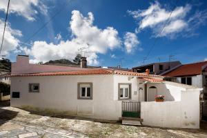 une maison blanche avec un toit rouge dans l'établissement Dom Pipas Houses - Batista & Marcelino Lda, à Sintra