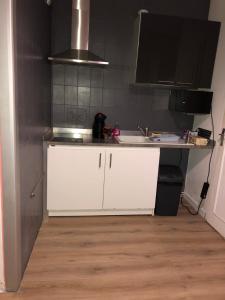 - une cuisine avec des placards blancs et un évier dans l'établissement Maison/Studio Clichy sous bois/Le Raincy, à Clichy-sous-Bois