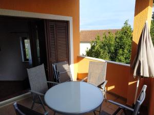 d'une table et de chaises sur un balcon avec une fenêtre. dans l'établissement Vila Sanja, à Premantura
