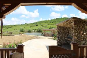 a view from the porch of a house with a stone fireplace at Ardelean Lake House in Doştat