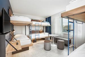 a bedroom with bunk beds and a living room at H2 Hotel München Olympiapark in Munich