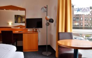 a hotel room with a desk with a computer and a table at Palazzo Hotel - direkt im Zentrum in Mönchengladbach