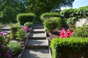 een tuin met een pad met bloemen en struiken bij Nettes Appartement in Mönchengladbach