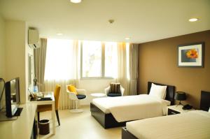 una camera d'albergo con 2 letti e una scrivania di Minh Khang Hotel ad Ho Chi Minh