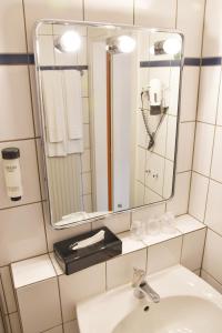 a bathroom with a sink and a mirror at Palazzo Hotel in Mönchengladbach