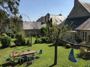 a garden with a picnic table and chairs and a tree at La Closerie Teranga in Bayeux
