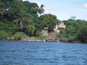 people are standing on the shore of a body of water at Linda Surf House Apartamentos in Itacaré