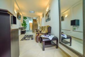 a living room with a chair and a mirror at Hostel Sinj in Sinj