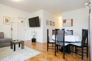 uma sala de estar com uma mesa e cadeiras e um sofá em Luxury Apartment ELA em Split