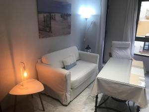 a living room with a white couch and a table at Center Flat Reyes Catolicos in Córdoba