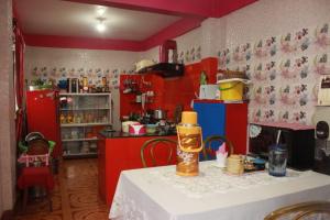 a kitchen with red cabinets and a table with a white table sidx sidx at Rambler's Nesting Homestay in Darjeeling