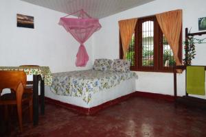 a bedroom with a bed and a table and a window at Grace Homestay in Negombo