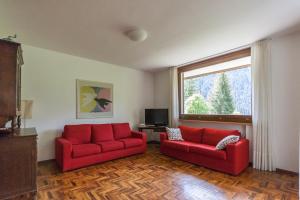 un soggiorno con 2 divani rossi e una finestra di Villa Licia a Falcade