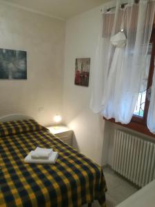 una camera con un letto a scacchi giallo e nero di Residence La Madonnina a Peschiera del Garda
