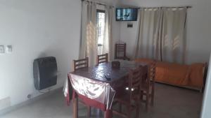 a dining room with a table and chairs and a television at Cabañas Corazon de Maria in Merlo