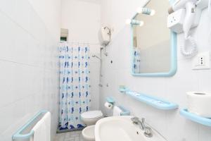 W łazience znajduje się umywalka toaletowa i lustro. w obiekcie Villa Panoramica - Ischia Ponte w mieście Ischia