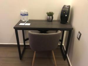 a black desk with a chair and water bottles at Hotel La Torre San Francisco in San Francisco del Rincón