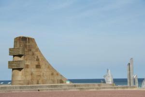a stone monument with the ocean in the background at Appartement OMAHA BEACH in Saint-Laurent-sur-Mer