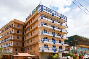 ein hohes Gebäude mit einem Schild darüber in der Unterkunft G-One Hotel Kampala in Kampala