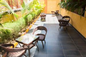 eine Terrasse mit Tischen, Stühlen und Pflanzen in der Unterkunft G-One Hotel Kampala in Kampala