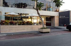 a building with a tree in front of it at Estelar Apartamentos Bellavista in Lima