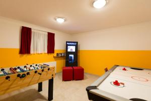 a room with a ping pong table and a video game at Haus Central Lofer in Lofer