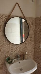 La salle de bains est pourvue d'un lavabo et d'un miroir. dans l'établissement Villa Rosalba, à Polignano a Mare