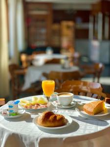 une table recouverte de assiettes de nourriture et de jus d'orange dans l'établissement Hotel La Cruz, à Muxía
