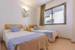 une chambre avec deux lits et une fenêtre dans l'établissement Zeus Sant Jordi, à Salou