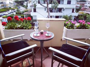 d'une petite table et de chaises sur un balcon fleuri dans l'établissement Luxury Apartment Magnolia Terrace, à Fregene