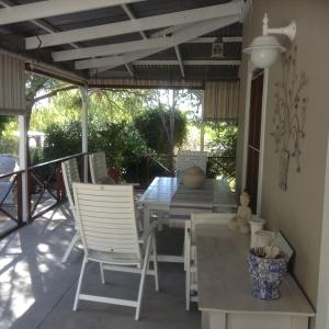 a patio with a table and chairs on a porch at LAVENDERS COTTAGE in Prince Albert +15 photos