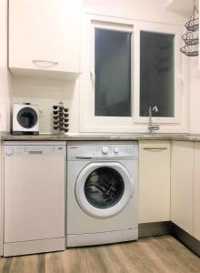 eine Küche mit einer Waschmaschine und einem Waschbecken in der Unterkunft Happy Home Getxo Beach in Getxo
