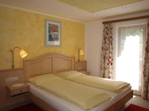 a bedroom with a bed and a window at Hotel-Restaurant Burgblick in Dorfgastein