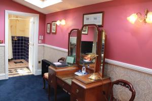 a dressing room with a vanity and a mirror at The PitStop in Bishops Stortford