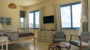 sypialnia z łóżkiem i salon z oknami w obiekcie ARTSEA Studio Apartment with sea view w mieście En Hod