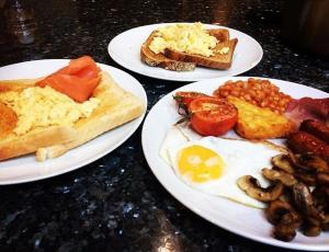 three plates of breakfast foods on a table at The Castleton in Swanage