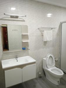 a bathroom with a toilet and a sink and a mirror at Hôtel des Jardins in Abidjan