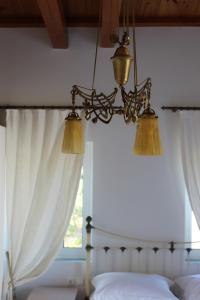 a chandelier is hanging over a bed with a window at Mando Beachfront in Stafylos
