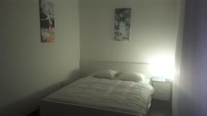 a small bedroom with a bed and two pictures on the wall at Apartmán - súkromie v meste (1) in Bratislava