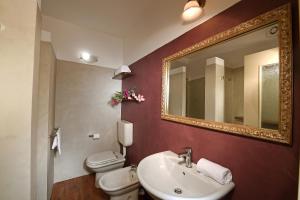a bathroom with a sink and a toilet and a mirror at Agriturismo Il Gioco Dell'Oca in Barolo