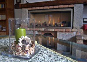 uma vela e uma flor sobre uma mesa em frente a uma lareira em Casa Hotel Civitella em Civitella Alfedena
