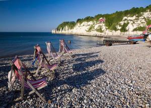 a group of lawn chairs sitting on a rocky beach at Belmont House Beer - Adults Only - Free Parking in Beer