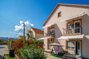a white building with a table and an umbrella at Belane Apartments in Tivat