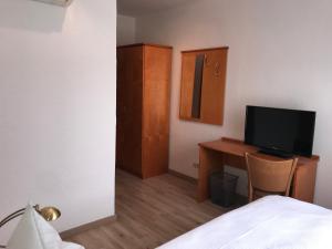 1 dormitorio con 1 cama y escritorio con TV en Hotel Sonnenschein nähe Messe und Flughafen en Düsseldorf