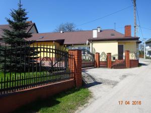 a house with a wrought iron fence and a driveway at Agroturystyka Przy Świerku in Chęciny