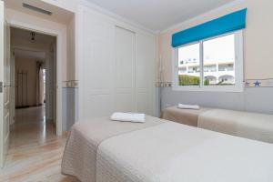 um quarto branco com 2 camas e uma janela em Burriana Playa Ibnsadi Nerja em Nerja