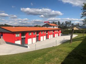 a red and white building with a parking lot at Motel Venus Santiago in Santa María