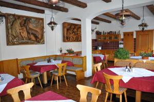 a restaurant with tables and chairs and a painting on the wall at Bergfrieden Leutasch/Seefeld in Leutasch