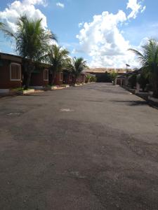 un parking vide avec des palmiers et un bâtiment dans l'établissement Medieval Motel e Hospedagem, à Ribeirão Preto